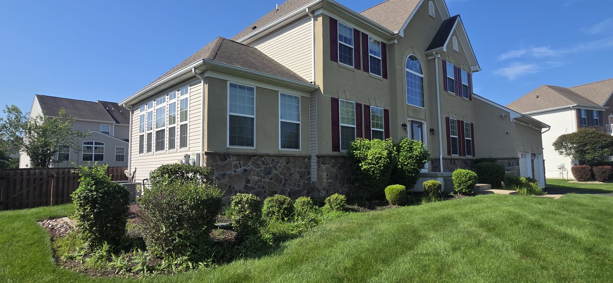 Side view of weedy front beds and untrimmed shrubs at a Hillsborough, NJ home before mulching