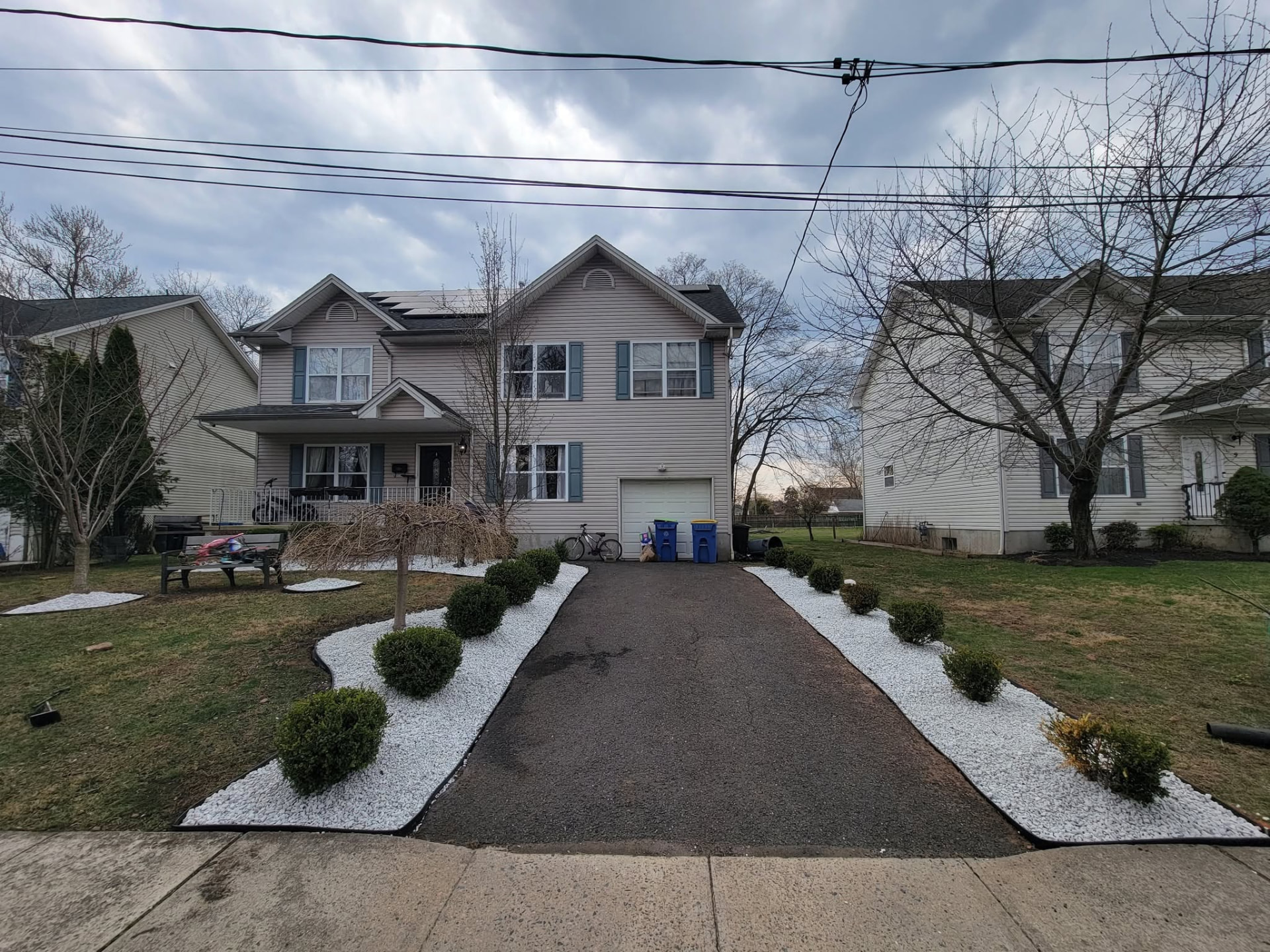 Finished front yard in Manville, NJ with white stone driveway border beds and evenly spaced boxwoods